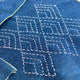 Close-up of blue fabric with white embroidery patterns
