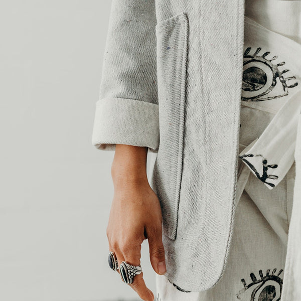 cropped image showing the cuff and front panel of a woman wearing a denim artist jacket