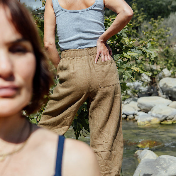Two women standing outdoors with a natural landscape in the background