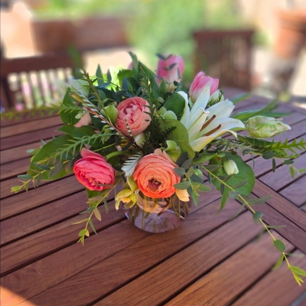Floral arrangement on a wooden table with a blurred garden background
