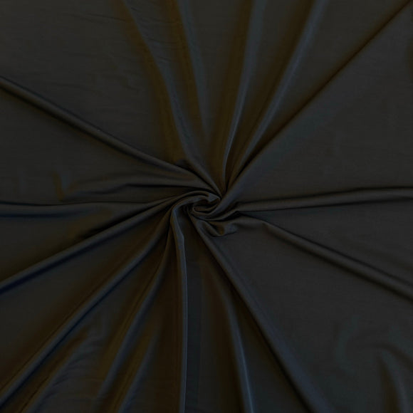 Dark charcoal gray fabric gathered in a spiral pattern to show its drape and texture.