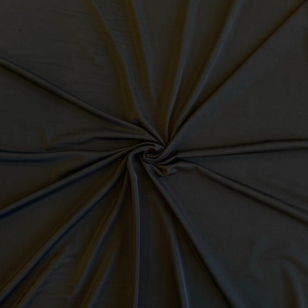 Dark charcoal gray fabric gathered in a spiral pattern to show its drape and texture.