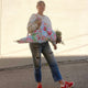 Person holding a colorful floral bag outdoors with a plain background