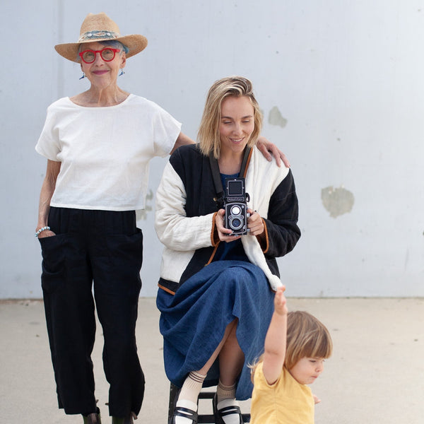 woman wearing the natural hemp crop top with her hand on the shoulder of another woman and a small child in the foreground