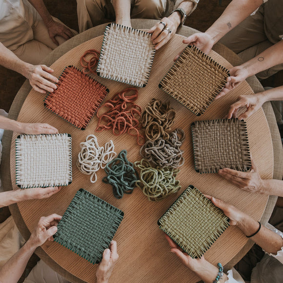 People around a table with woven placemats and strings.