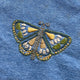 Embroidered butterfly design on a denim fabric background