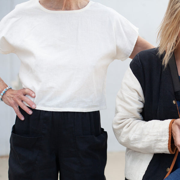 cropped image of a woman wearing the natural hemp crop top with one hand on her hip 