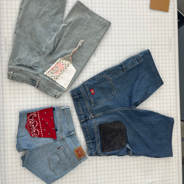 Jean shorts with added patches to each pair on a work table