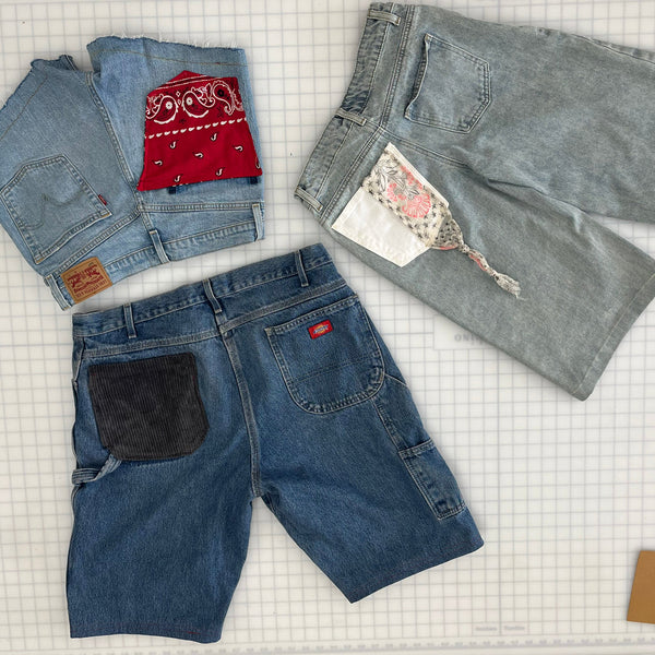 Folded jeans on a checkered tablecloth with visible brand labels.