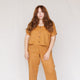 woman with auburn hair wearing rust colored linen crop top with buttons on front 